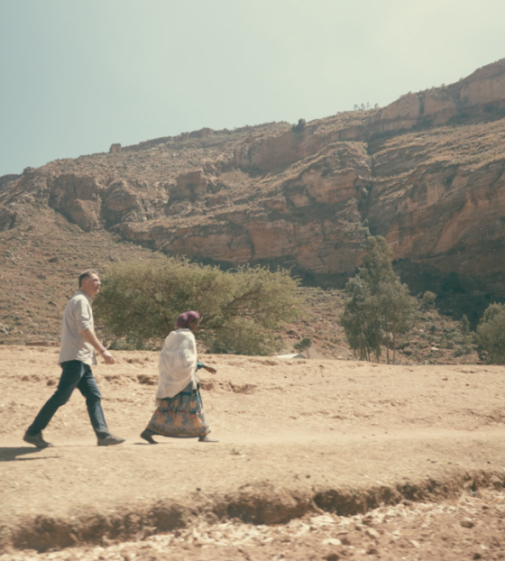 Magnus MacFarlane-Barrow walks in Tigray, Ethiopia, with a local woman.