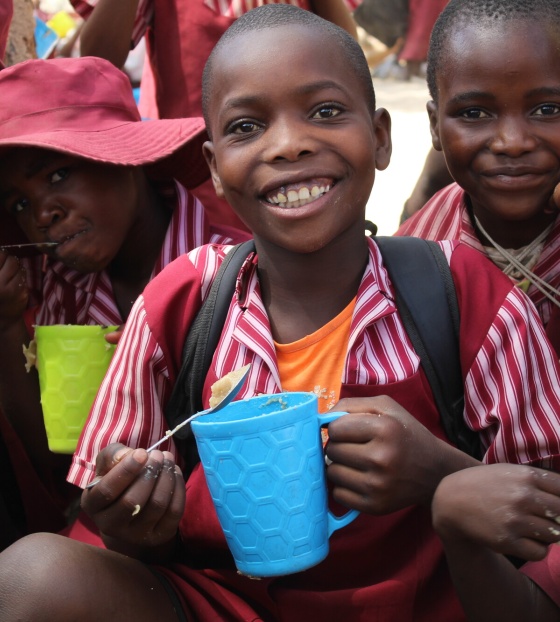 Children smiling while holding Mary's Meals mugs