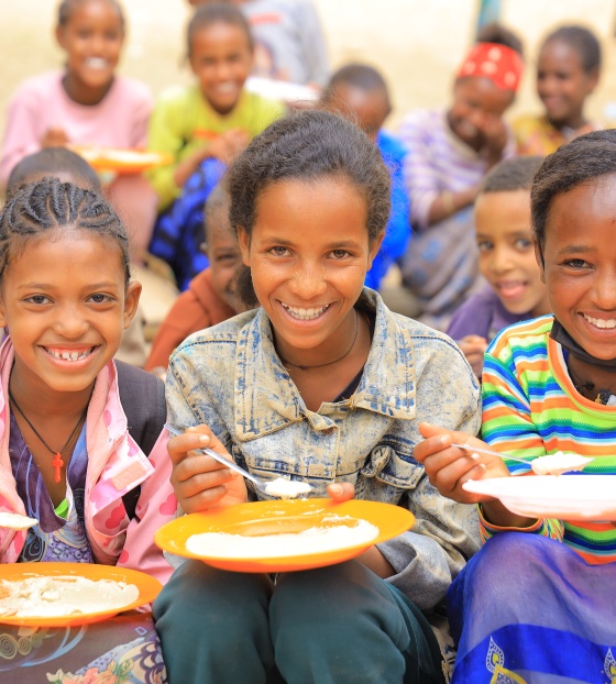 Happy girls in Ethiopia eating 
