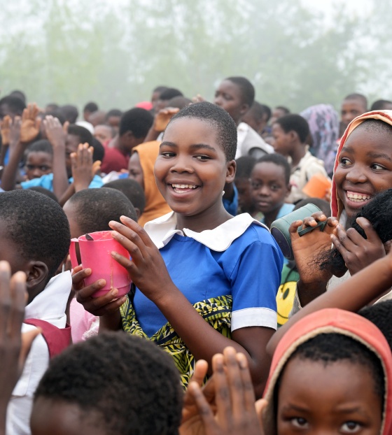 Children smile as they line up for porridge in Malawi.