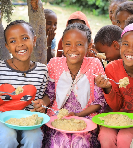An image of three children in Ethiopia eating their school meals