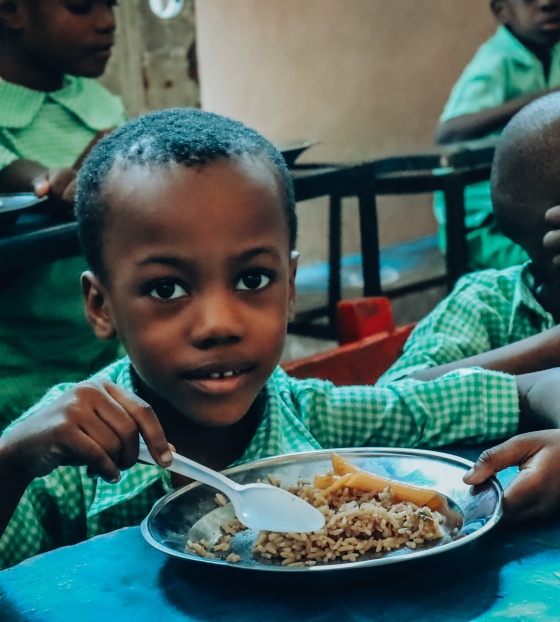 Boys in Haiti classroom eating from a boy