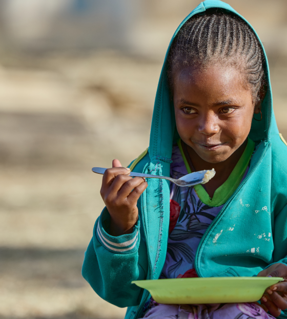 Girl eating a bowl of porridge in Ethiopia