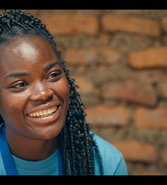 A young woman in a blue t-shirt smiles