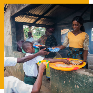 A volunteer serves food to a child