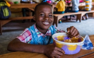 Child in Liberia enjoying their school meal