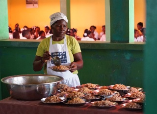 Volunteer cook serving meals in Haiti