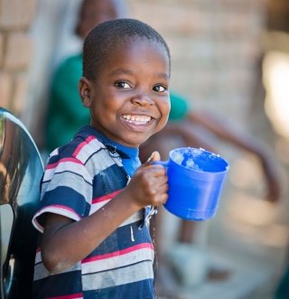 Child holding mug of Marys Meals