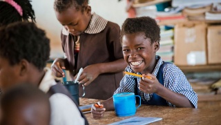 Child in Zambia enjoying Marys Meals in class