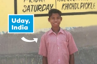 12 year old Uday from India standing in front of a school lunch menu