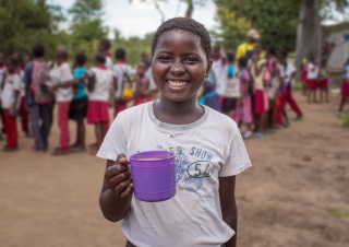 Child holding mug of food