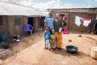 Fred, his wife, Nabintu-Louise and their three children standing in front of their home in Turkana