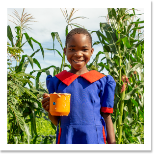 Child in Malawi holding their mug of porridge