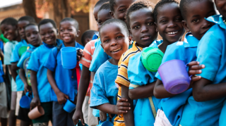 Children queueing with mugs