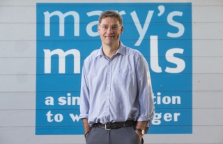 Mary's Meals founder Magnus MacFarlane-Barrow standing in front of Mary's Meals sign