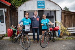Jacob and Lucia with their bikes standing in front of The Shed in Dalmally with Magnus MacFarlane-Barrow
