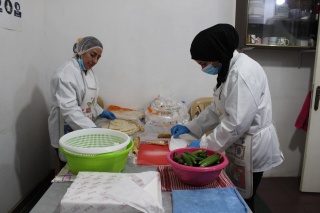 Two volunteer cooks prepare food for children in the kitchen