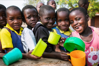 Children queueing with mugs