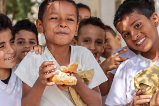 Children eating bread buns and cheese