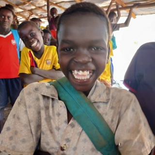 Thomas, a young boy smiling looking into the camera