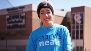 woman smiling with Mary's Meals t-shirt on 