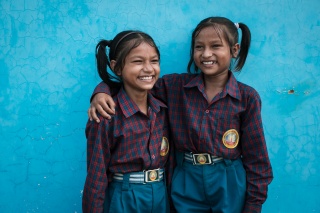 Siblings Jainab and Jubaida stand together smiling