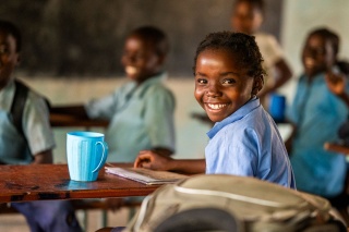 An image of a child in school with food