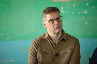Mary's Meals founder, Magnus MacFarlane-Barrow, sitting listening to a person not pictured
