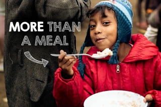 Image of a child in Madagascar smiling while holding their school meal