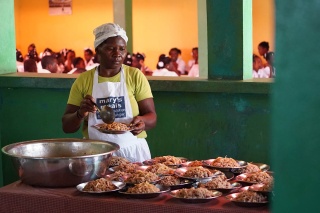 Image of a cook serving food in Haiti