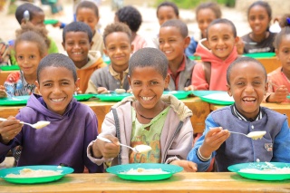 Image of children in Ethiopia sitting eating their school meal