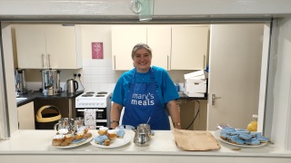 A volunteer in a kitchen wearing a Mary's Meals apron