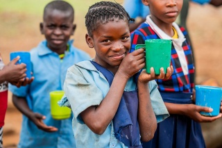 Image of a happy child holding their meal