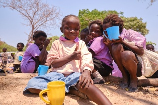 Image of a child in Zambia happy with their school meal