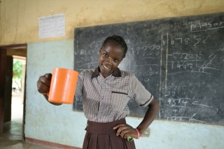 Image of a child holding thier school meal in the classroom