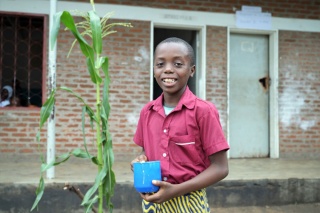 Image of a child holding their mug of porridge