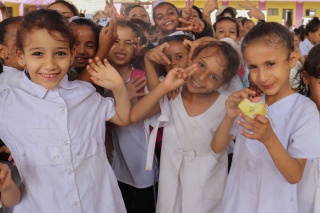 Image of children in Yemen looking happy after receinv their school meal