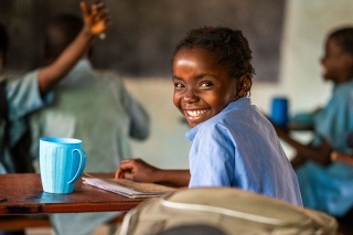 An image of a child in class enjoying a school meal