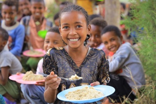 An image of a child in Ethiopia enjoying their school meal