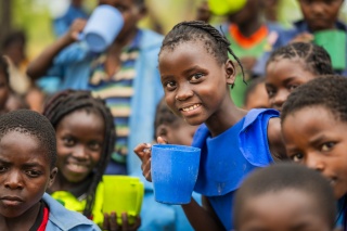 Child holding a blue mug