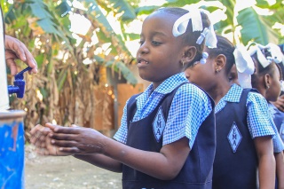 Image of a child in Haiti washing hands