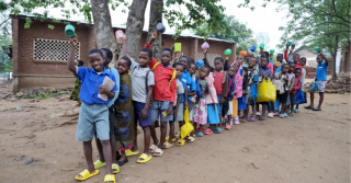 Children ready to receive their porridge in Malawi