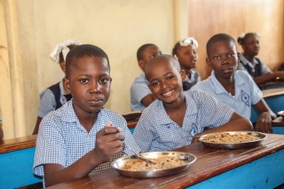 Boys in Haiti at a table eating food