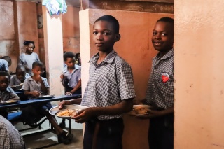 Boys in a Haiti school standing with plates of food