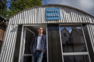 Magnus MacFarlane-Barrow stands in the doorway of the Mary's Meals shed