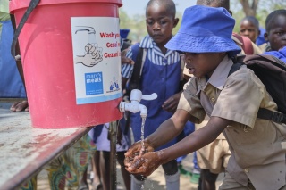 Child cleaning their hands with water in Zimbabwe