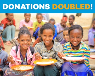 An image of three children sitting eating their school meal in Ethiopia