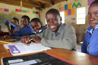 Boys studying in class whilst smiling