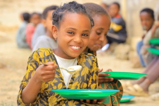 An image of a child in Ethiopia eating their school meal