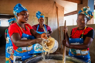 An image of volunteers in Zambia cooking meals for their children